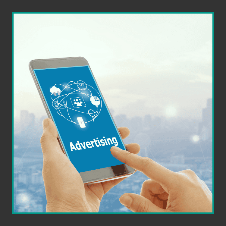 Eine Person hält ein Smartphone in der Hand, auf dem ein blauer Bildschirm mit dem Wort Advertising und Symbolen für digitales Marketing angezeigt wird, mit einer unscharfen Stadtlandschaft im Hintergrund.