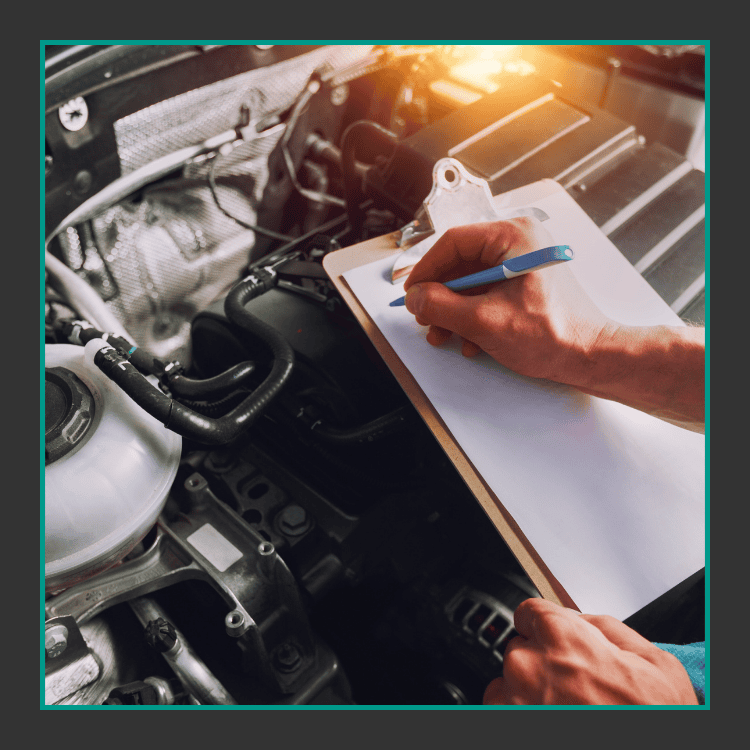 Eine Person, die ein Klemmbrett und einen Stift in der Hand hält, schreibt Notizen, während sie einen Automotor inspiziert, wobei das Sonnenlicht in den Motorraum scheint.